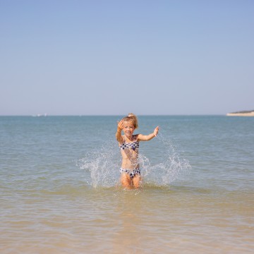 Petite fille jouant dans la mer